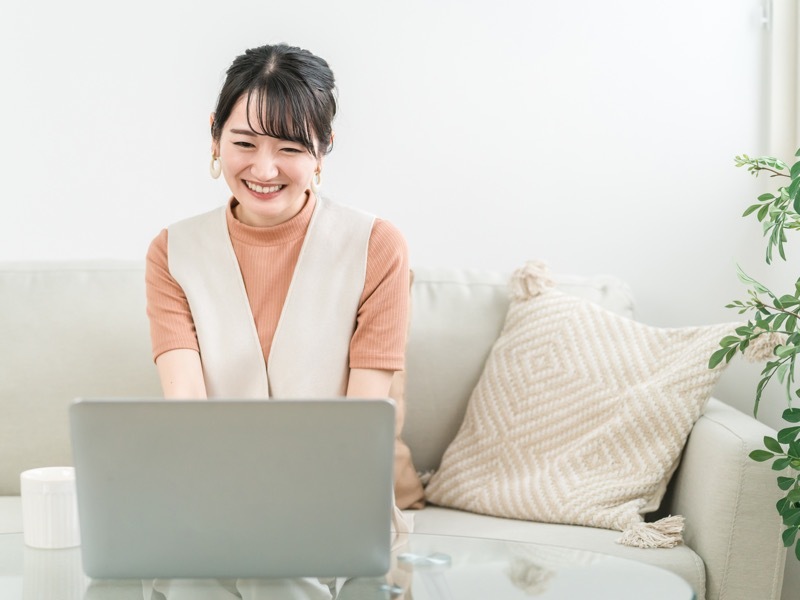 ソファでパソコン作業する女性