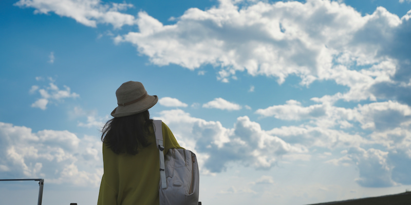 空を見上げる女性の後ろ姿