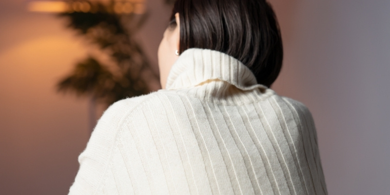 悩む女性の後姿の写真