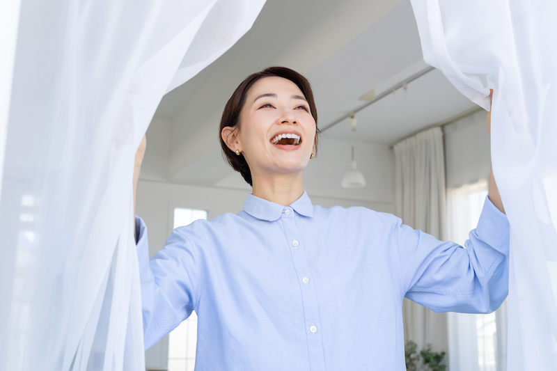 カーテンを開ける女性