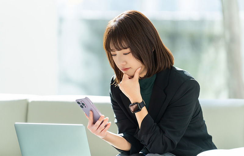 スマホを見て考える女性