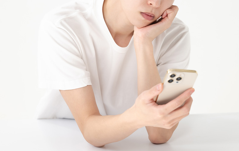 スマホを見て考える男性