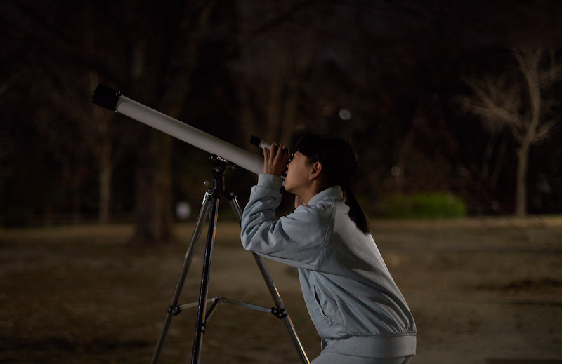 望遠鏡を覗く女性