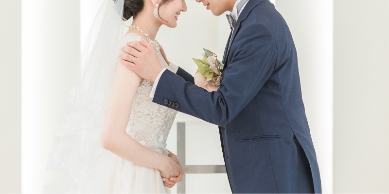 おでこをくっつけあって微笑む新郎新婦の写真の写真