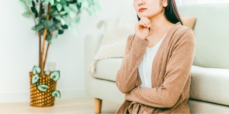 自室で考え事をする女性の写真