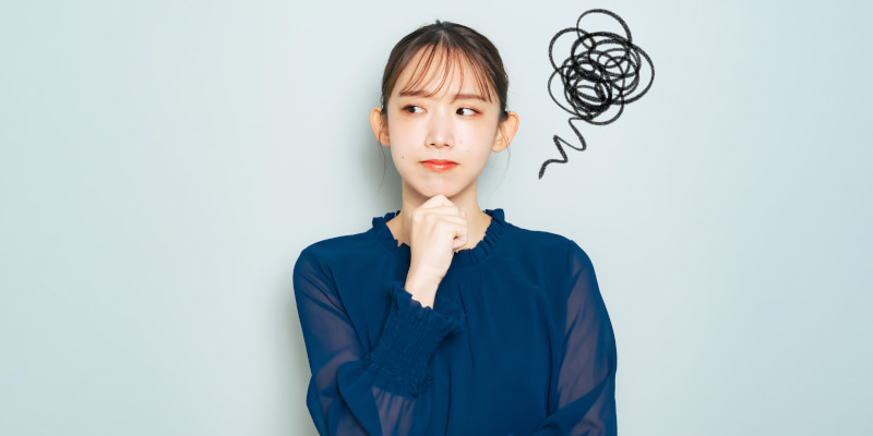 モヤモヤしながら考える女性の写真