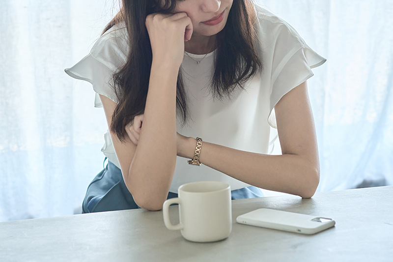 肘をついて考え込む女性