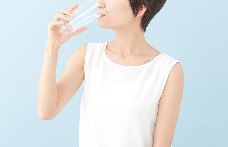 グラスの水を飲む女性