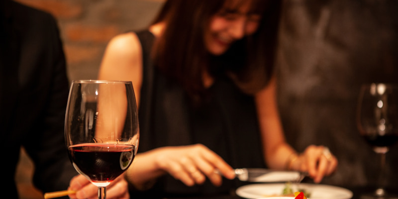 食事中の女性が会話相手の話で笑っている写真