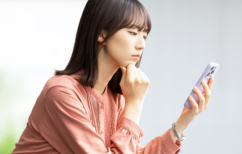 スマホを見て考える女性