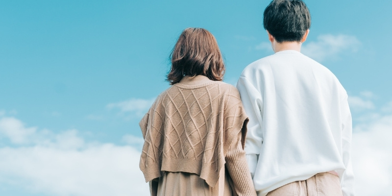 寄り添うカップルの後姿の写真