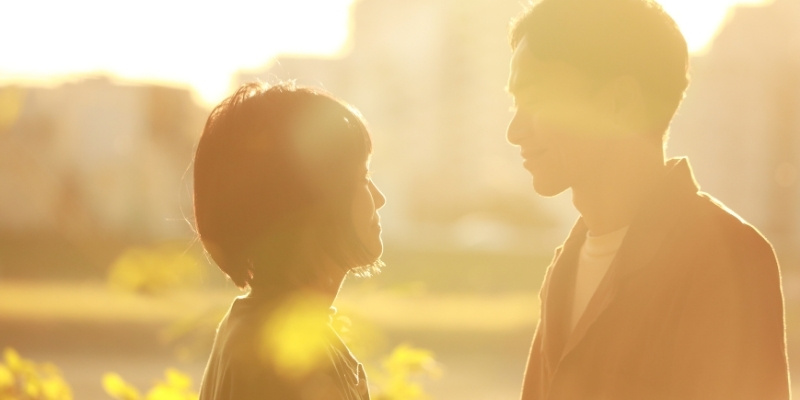 夕焼け前に微笑み合うカップルの写真