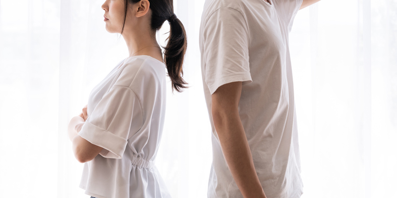 背中を向ける男女の写真