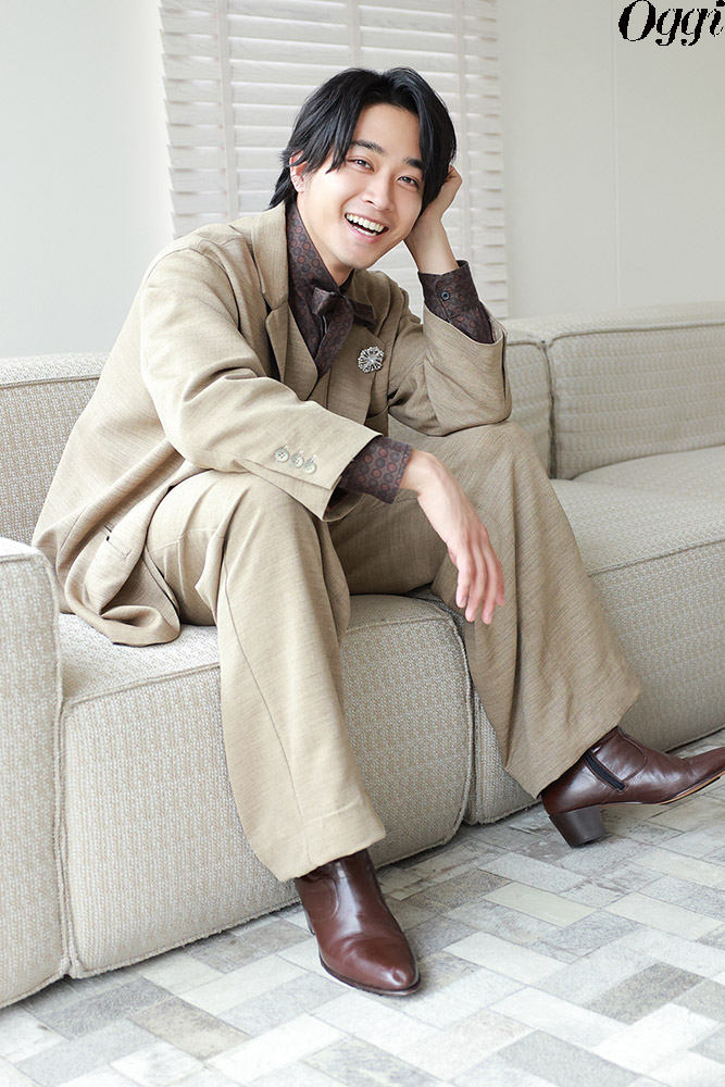 ソファに腰掛け笑顔の佐藤寛太さん