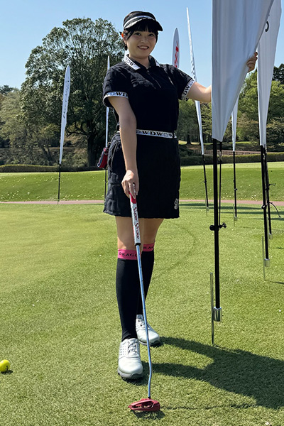 黒のゴルフウェアを着用した女性の写真
