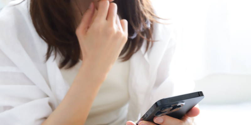 スマホを見ている女性の写真