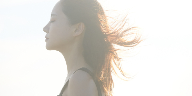 風を受ける女性の写真