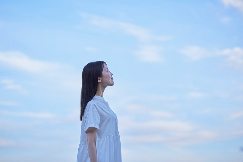 空を見てたたずむ女性