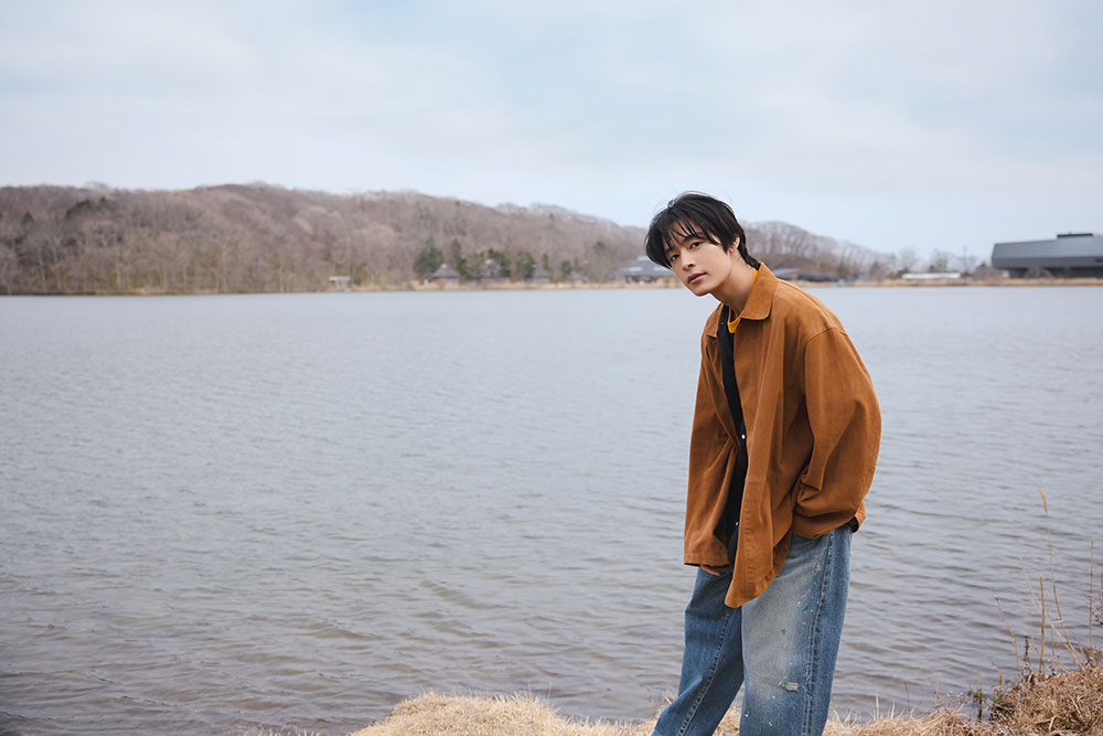 湖のほとりに立つ塩野さん