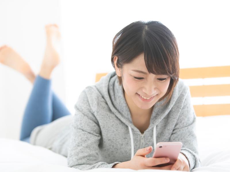 スマホで調べ物をする女性