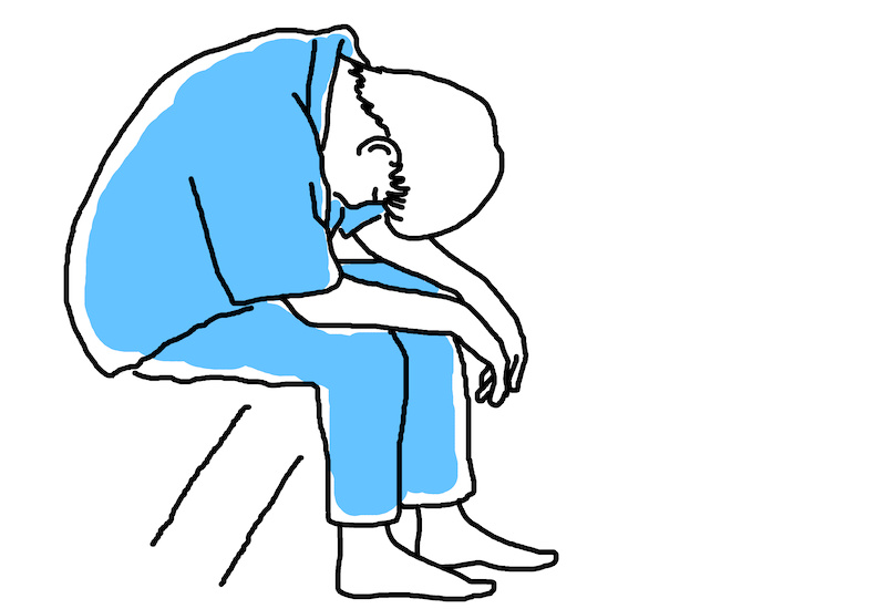 ベッドに座ってうなだれる人のイラスト