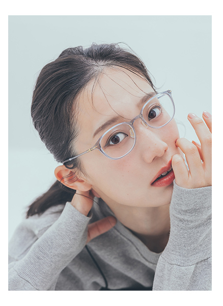 クリアフレームの眼鏡をかけた人のアップ写真