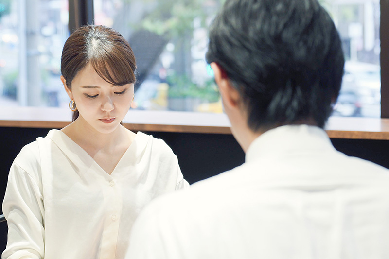 向かいあって話をする男女