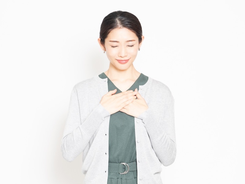 胸に手を当てる女性