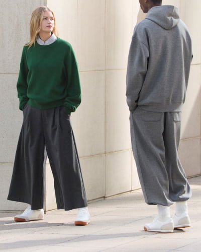 シャツ、ニット、キュロットを着た女性とスウェットセットアップを着た男性