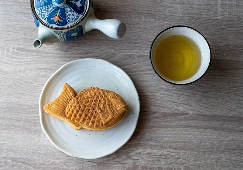 お皿にのったたいやきと急須、お茶の入った湯呑み