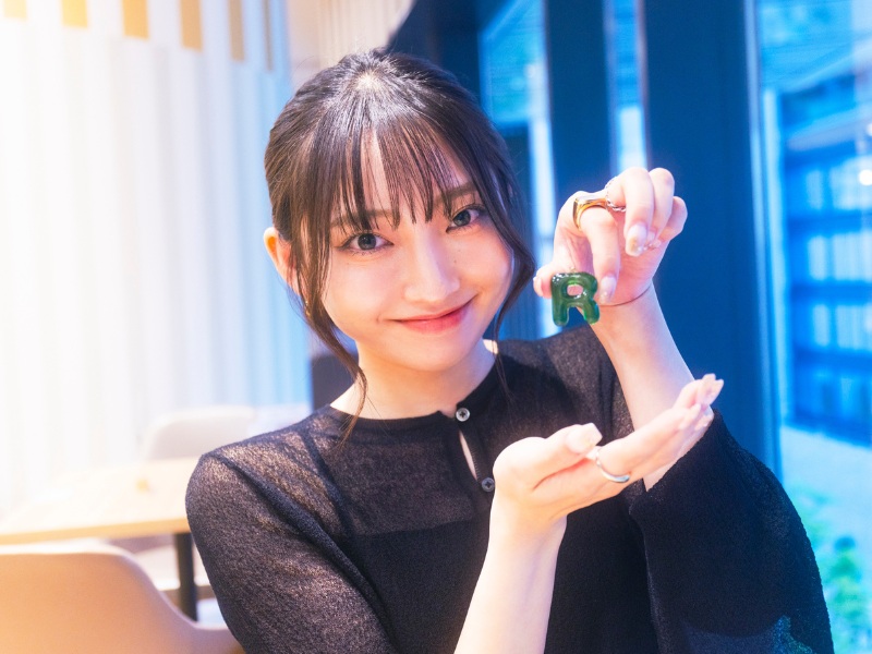イニシャルチャームを持つ松浦さん