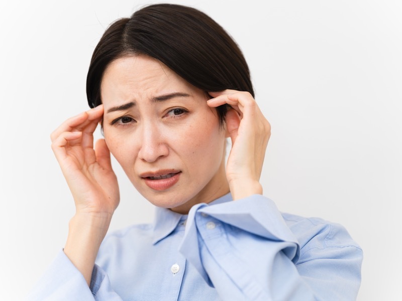 こめかみをおさえる女性