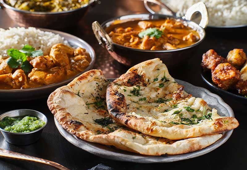 カレーやごはん、ナンが並ぶ食卓