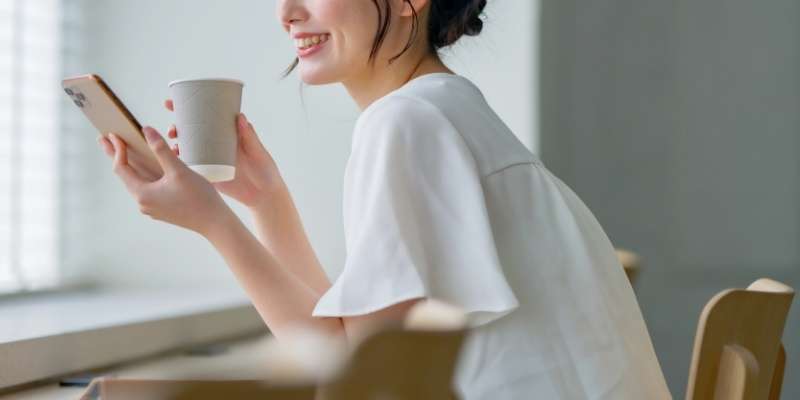 スマホを見てほほ笑む女性の写真