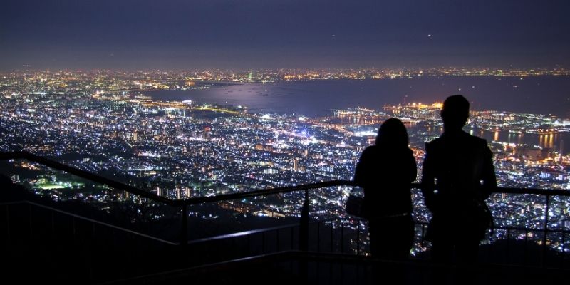 夜景を見ている男女のシルエット写真