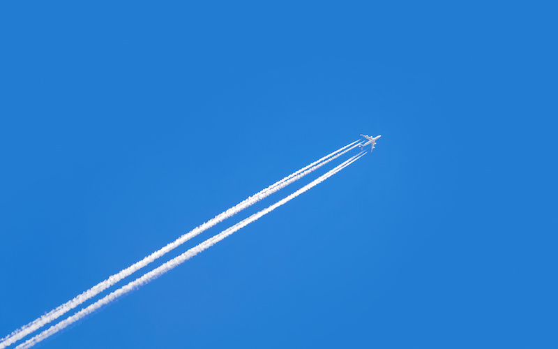 青空を飛んでいる飛行機の写真