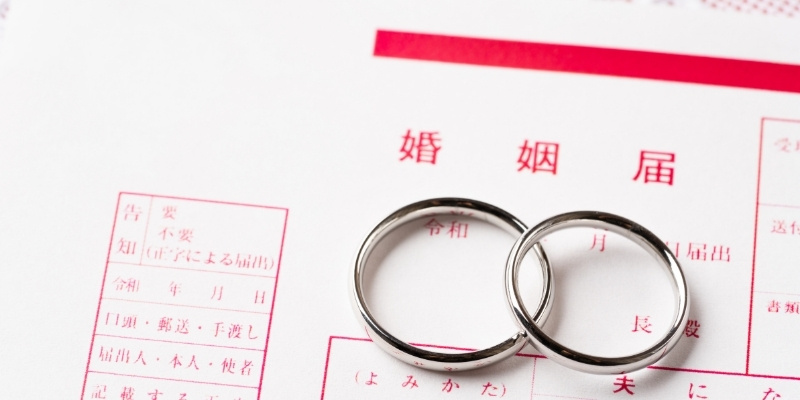 婚姻届の上にペアリングが置かれている写真
