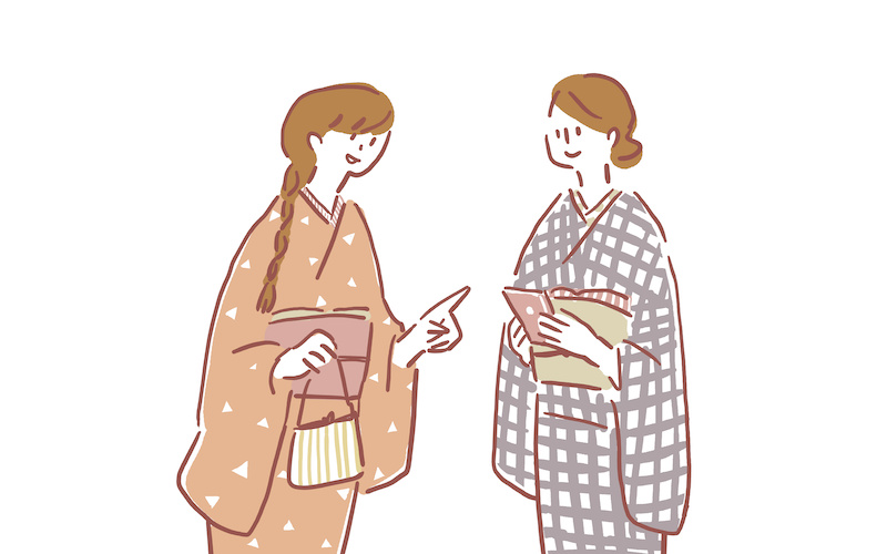 携帯を持つ着物を着た若い二人の女性（白背景）