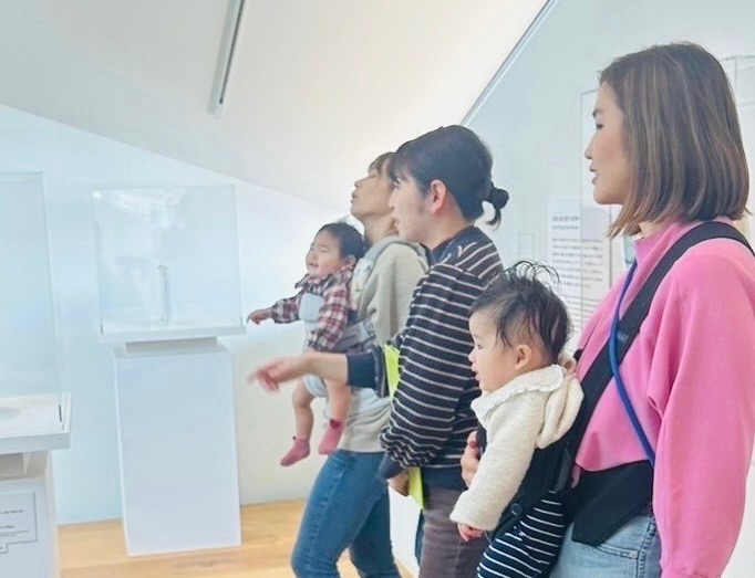 赤ちゃんを抱っこしてヨックモックミュージアムを楽しむ人々