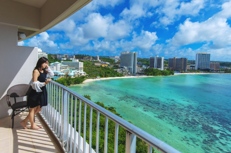 バルコニーから海を眺めている女性の写真