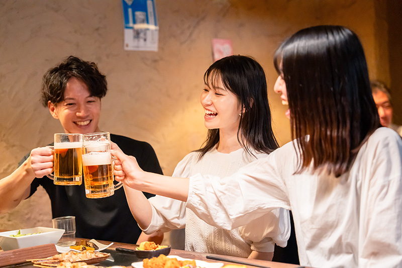 居酒屋でお酒を飲む若い男女