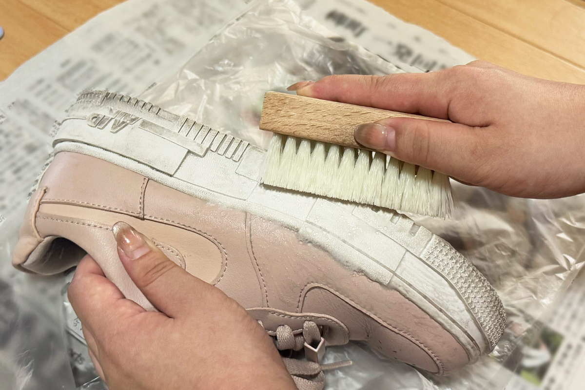 スニーカーをブラシで磨いている工程写真