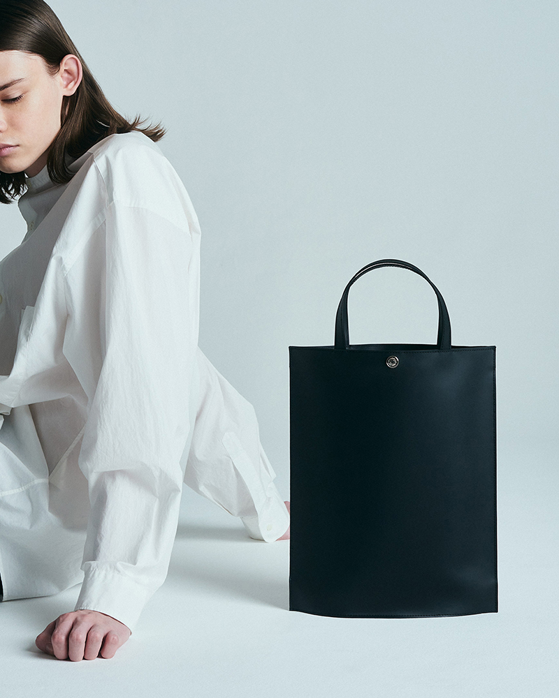 座っている人と黒いトートバッグ