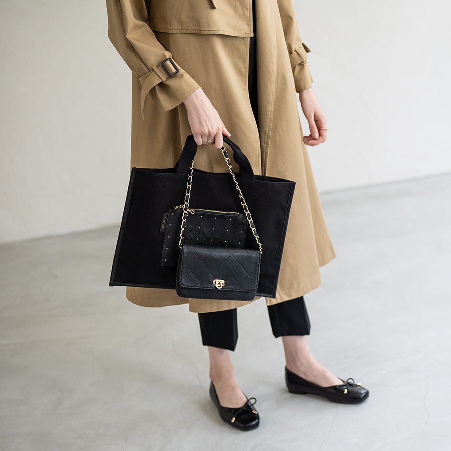 黒いハンドバッグとトートバッグを持っている人