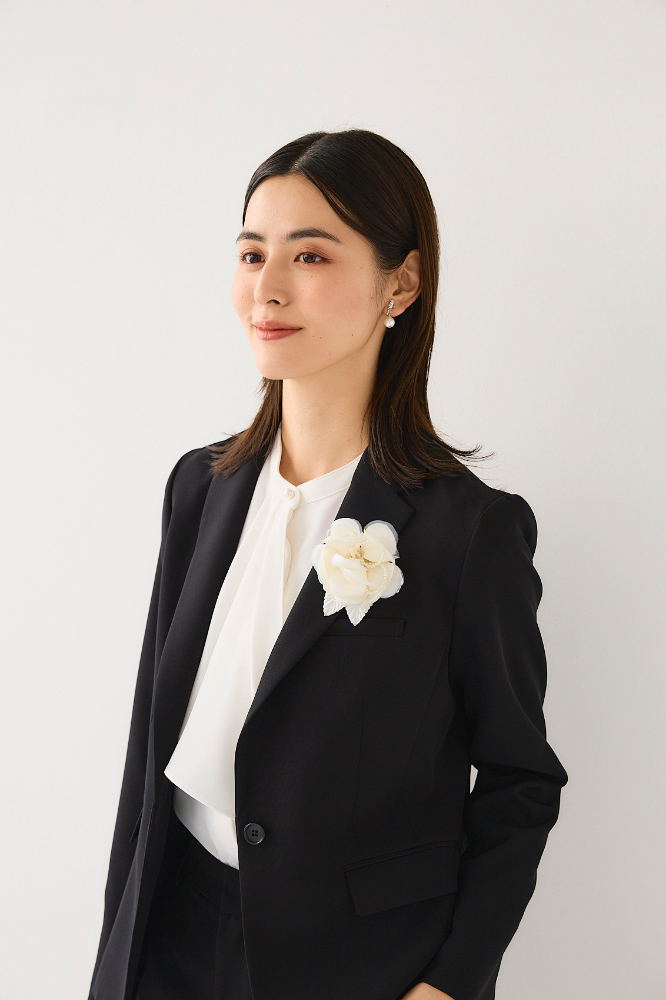 白のローズパールコサージュをつけた人