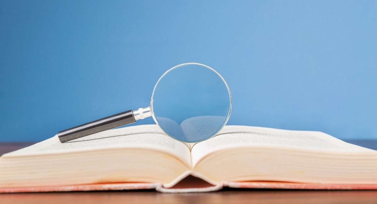 開かれた分厚い本とルーペの写真