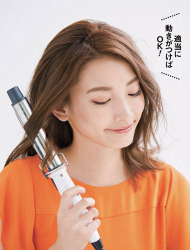 アイロンでサイドの髪を巻いている写真