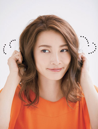 両手で髪にワックスを揉み込んでいる写真