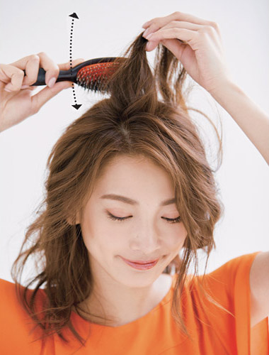 トップの髪にブラシをかけている写真