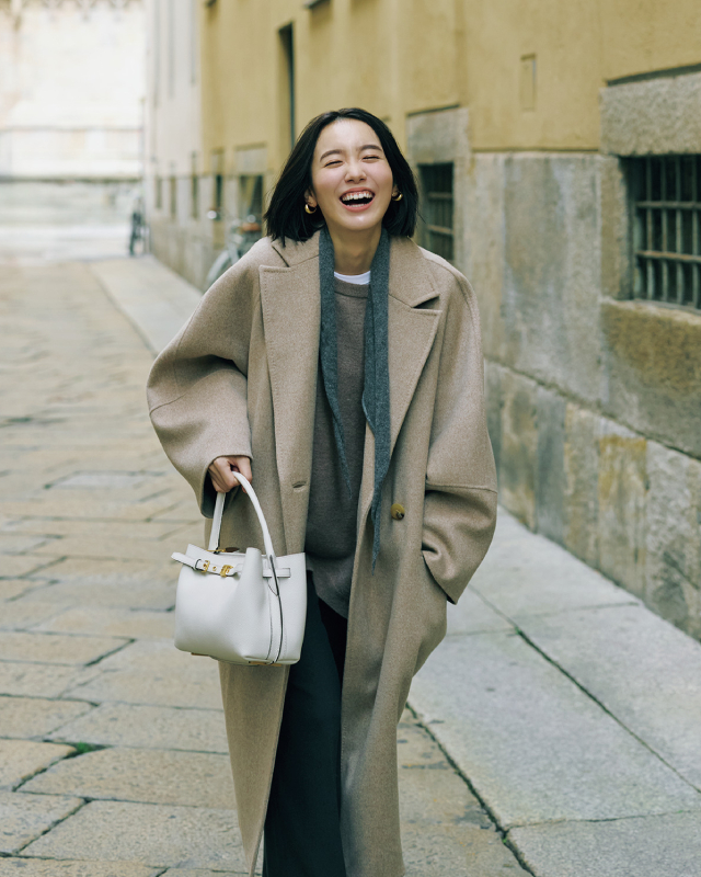 ベージュコート×ブラウンニット×白Tシャツ×グレーパンツ×白バッグコーデ